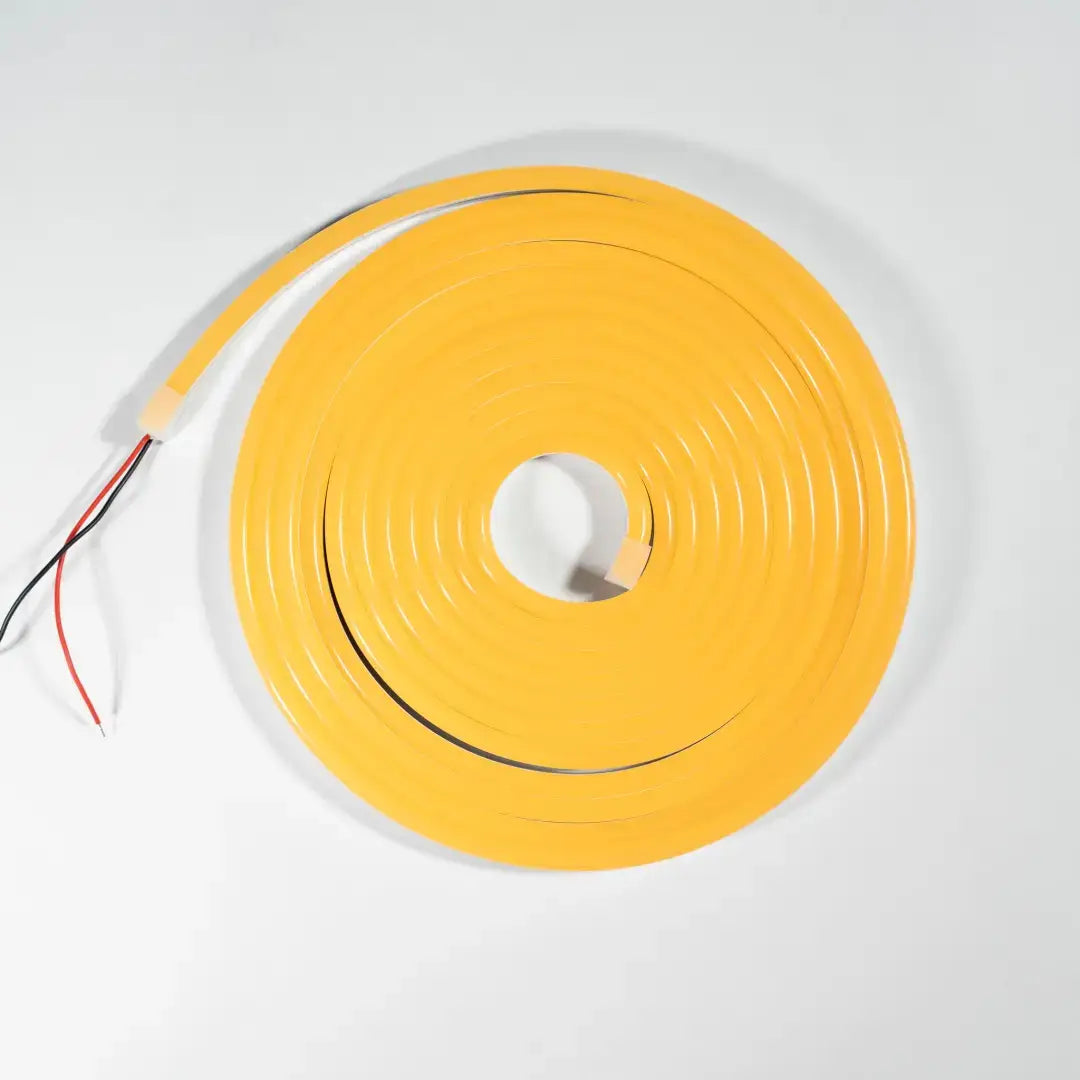 Flexible neon sun yellow LED strip light coiled in a circle with exposed wiring