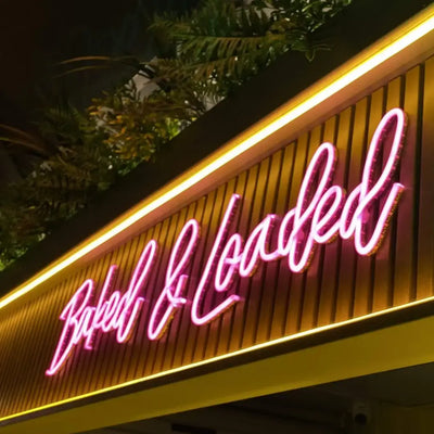 Pink pink neon sign reading Baked & Loaded on wood, flexible neon LED strip with pre-soldered ends