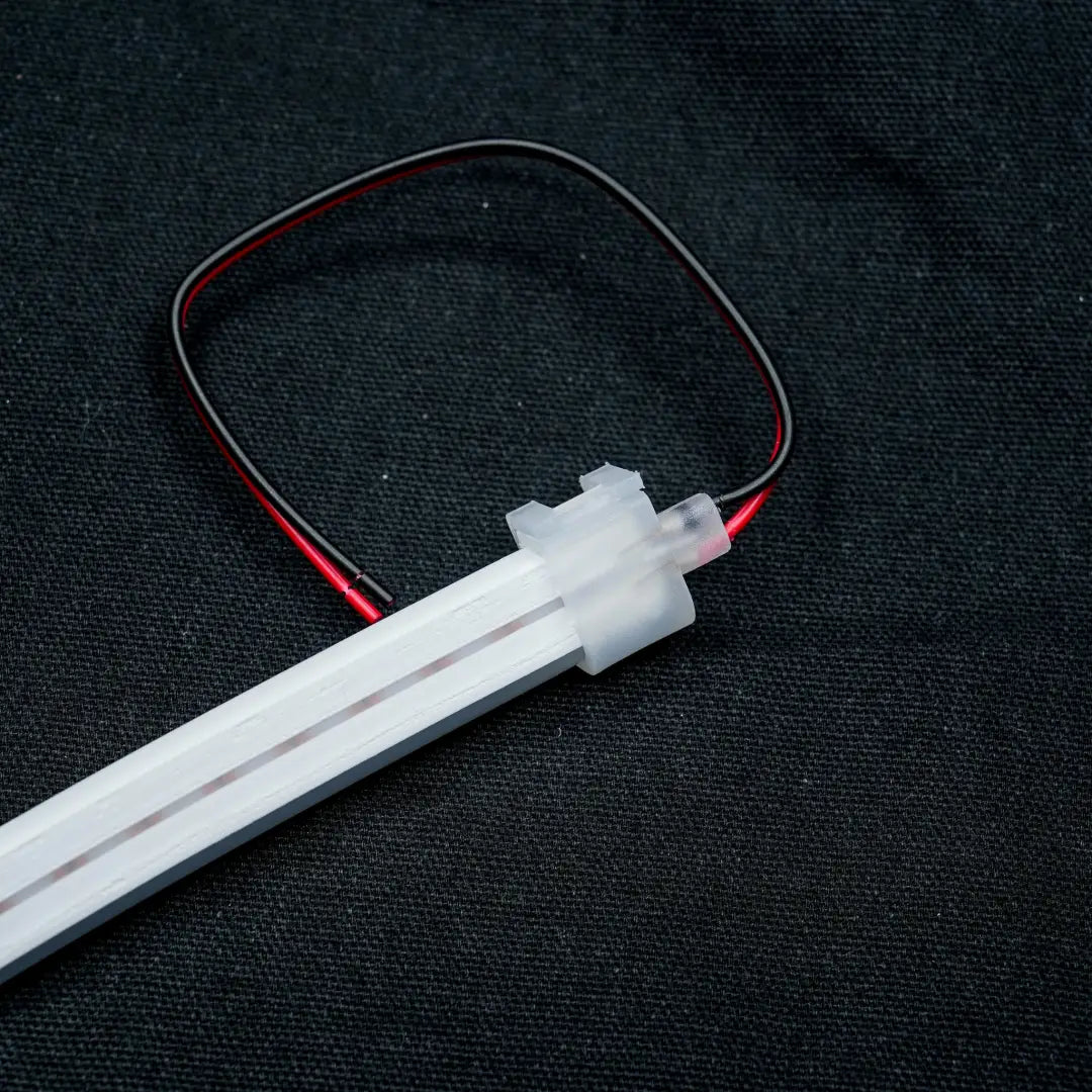 White LED strip with red and black wiring attached to an 8x16 Quick Connector for effortless linking