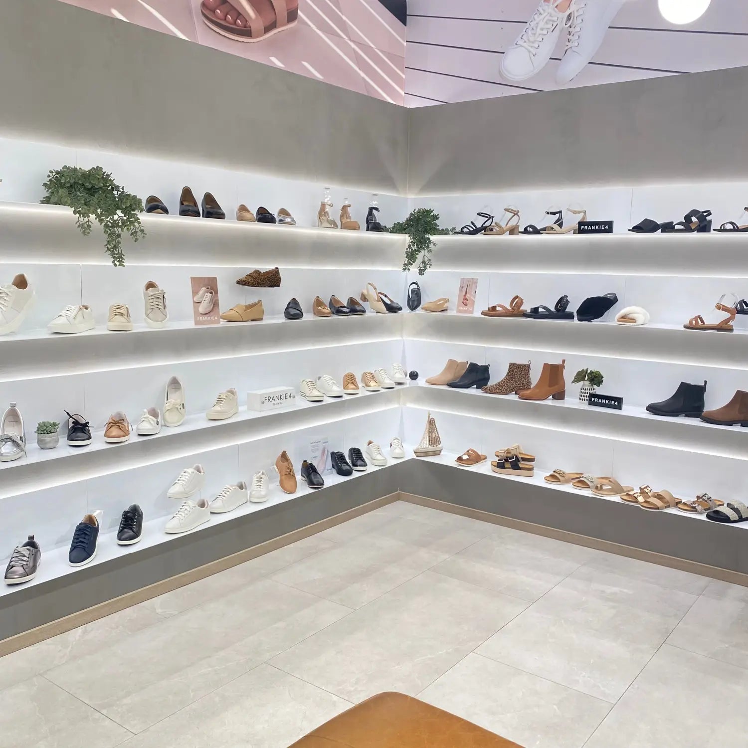 Clean white shelves displaying a collection of shoes and boots in various styles and colors