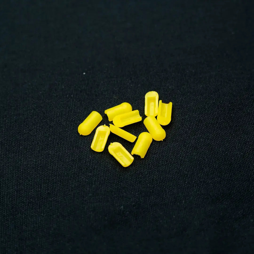 Yellow foam earplugs scattered on surface, vibrant lemon yellow flexible neon coloured end caps