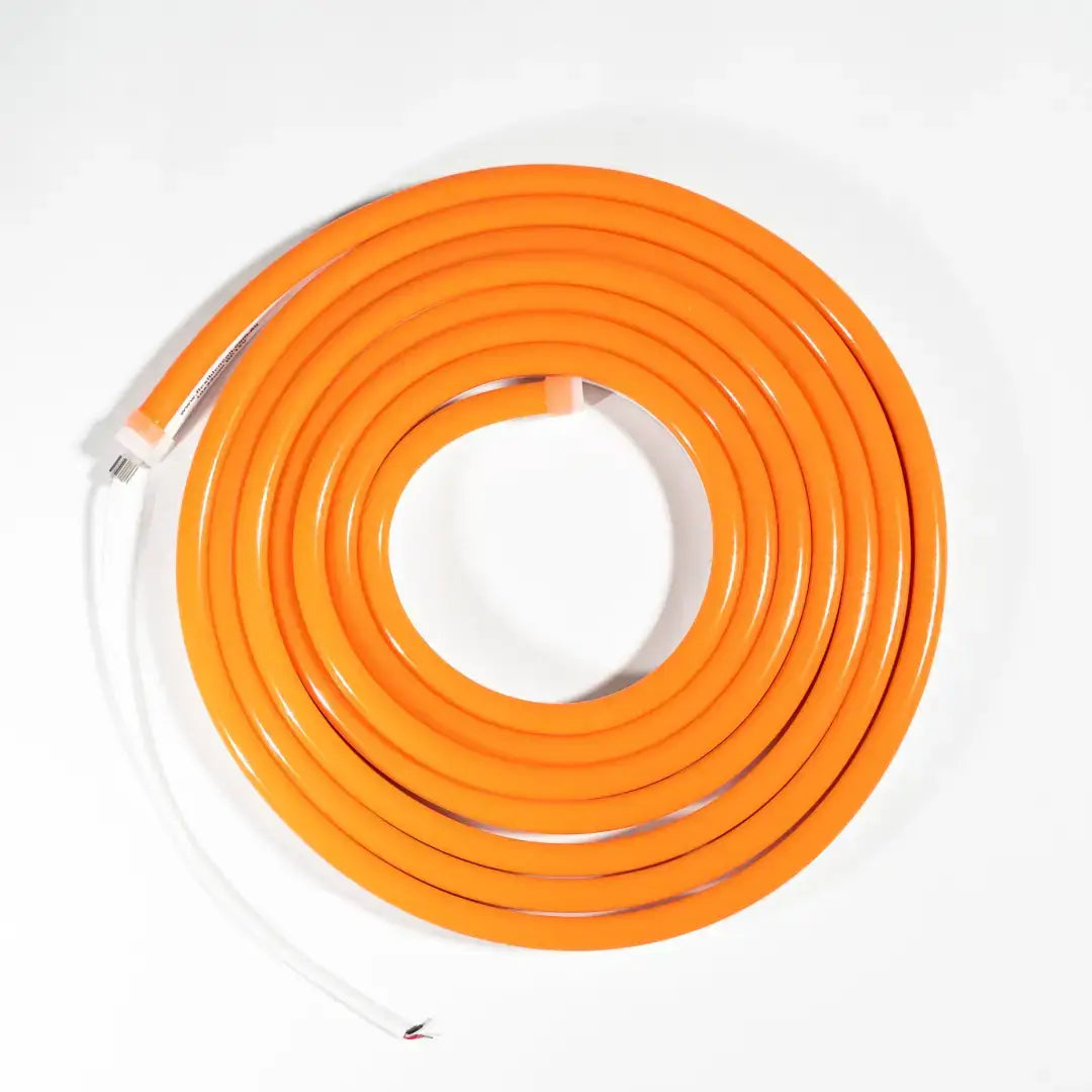 Coiled orange electrical extension cord with white ends for neon LED strip and architectural strips