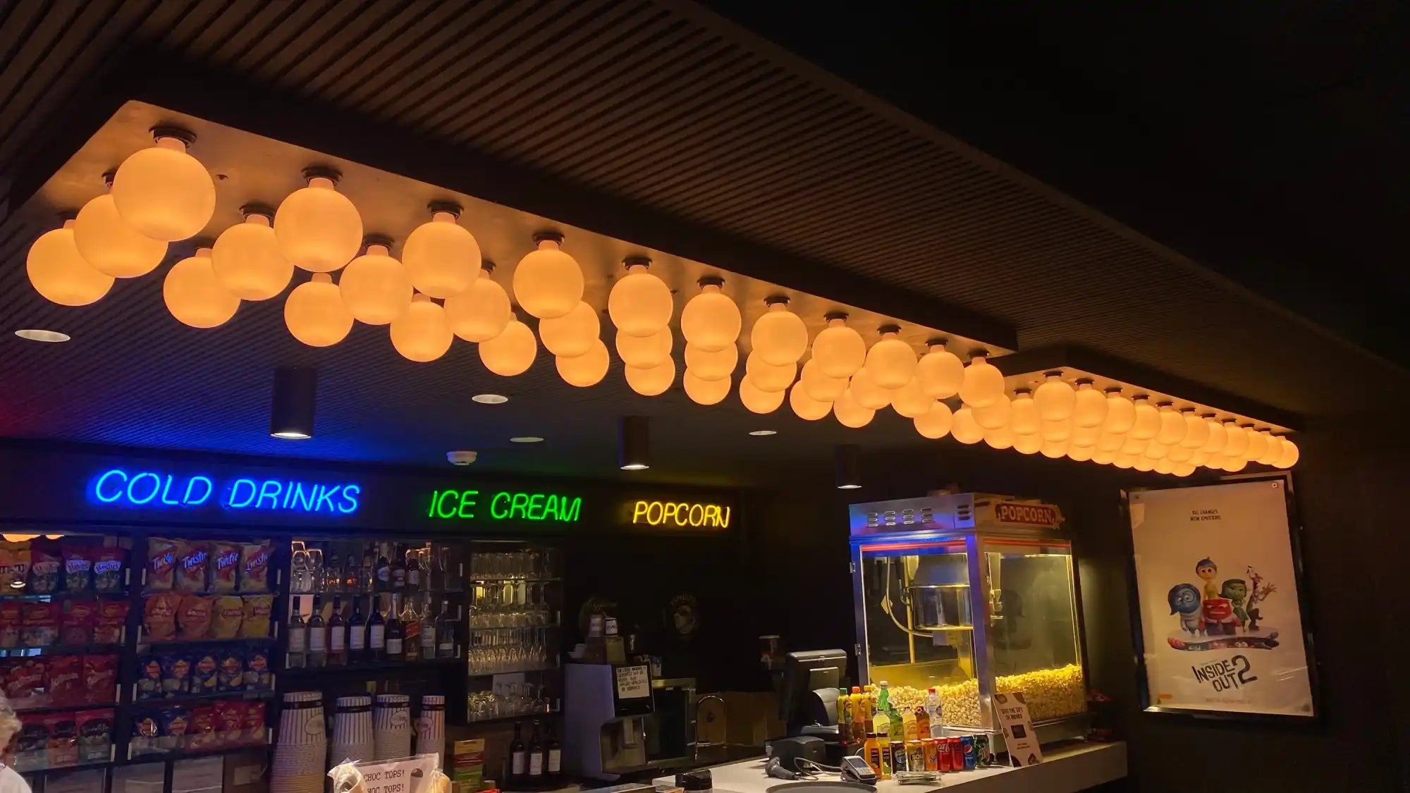 Row of glowing orange paper lanterns mounted in a line along the ceiling.