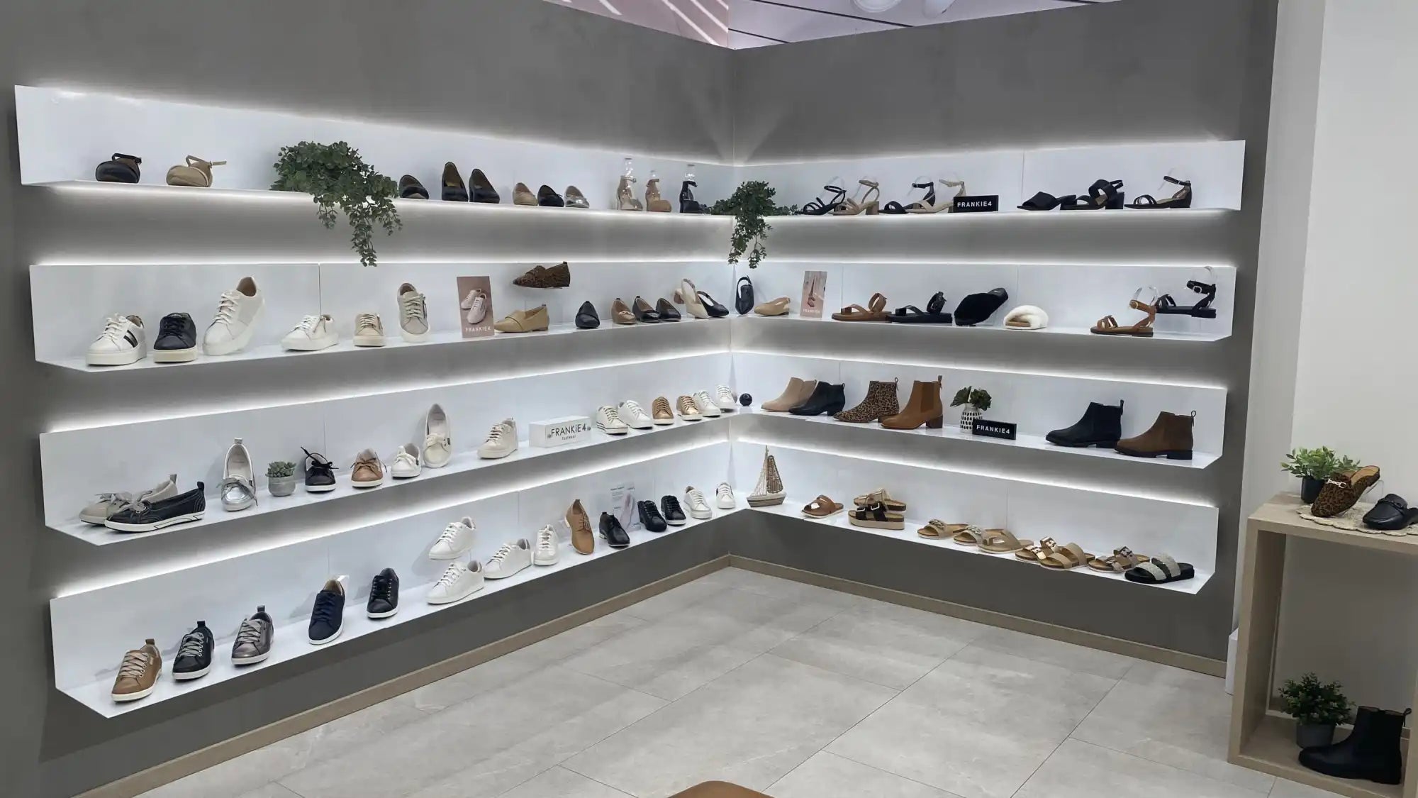 White floating shelves displaying a collection of shoes and sneakers.